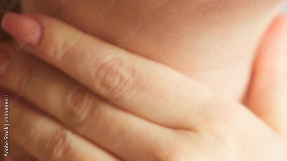 pain and dryness in the throat the first signs of the disease, a woman touches her throat with her hand, close-up pain and dryness in the throat the first signs of the disease, a woman touches her throat with her hand, close-up