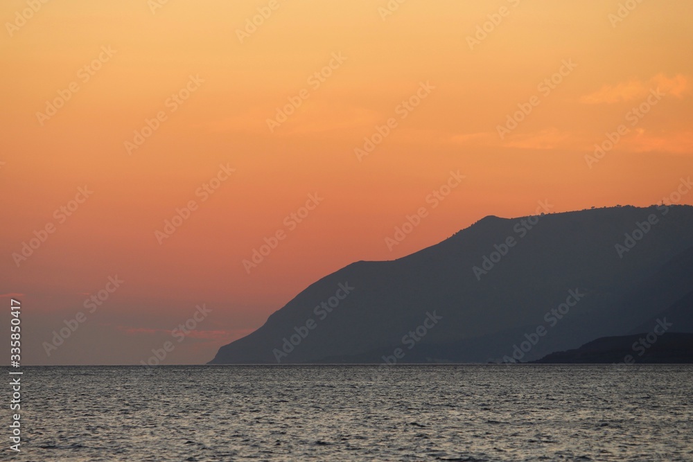 coucher de soleil avec des falaises et un ciel orange