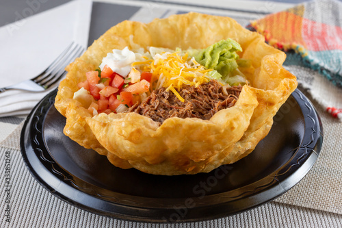 A view of a Mexican tostada taco salad, in a restaurant or kitchen setting. photo