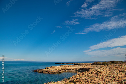 ocean shore made of stones, blue sky