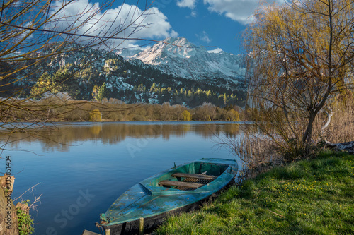 rowing boat is moored on the shore of a small lake in fine weather © karegg