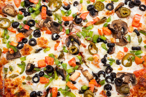 A top down view of a veggie pizza, as a background.