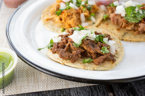 A closeup view of a carne asada taco, in a restaurant or kitchen setting.