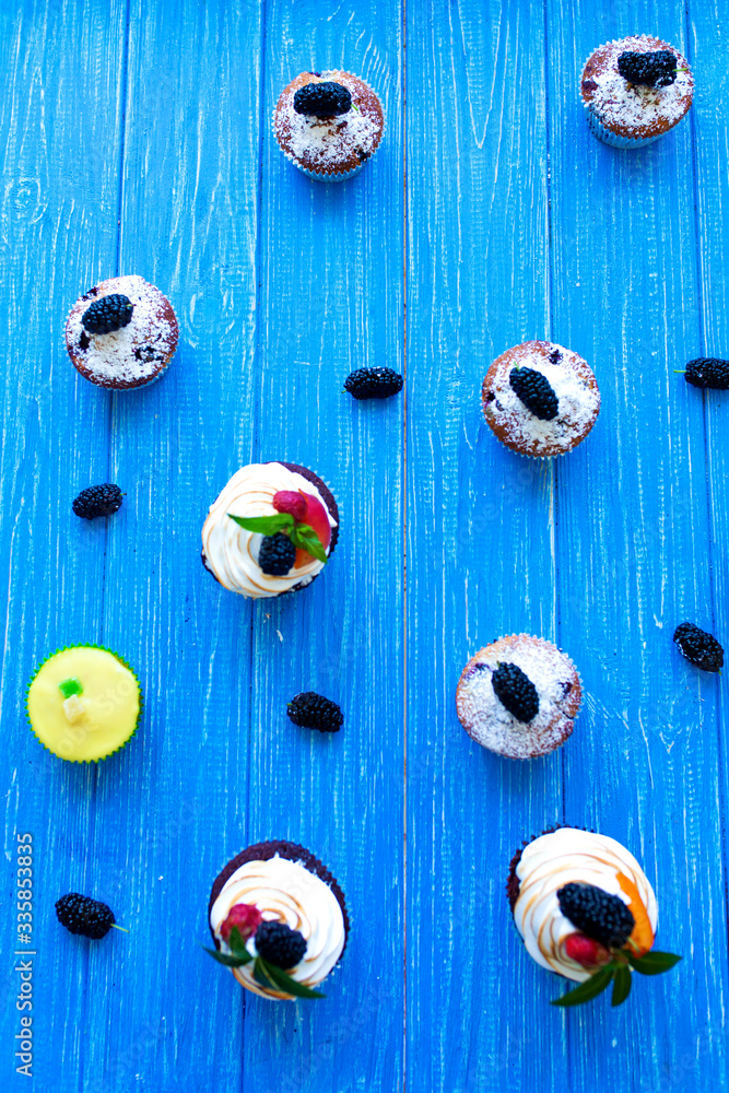 Freshly baked sweet muffins on a blue background. Sweet pastries, recipes, cooking Freshly baked sweet muffins on a blue background. Sweet pastries, recipes, cooking