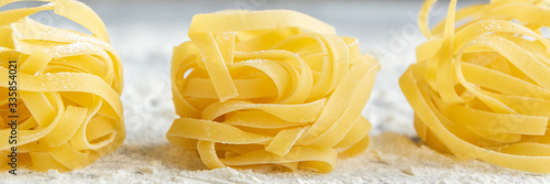 Cuadro en lienzo Handmade italian pasta - tagliatelle on grey floury background
