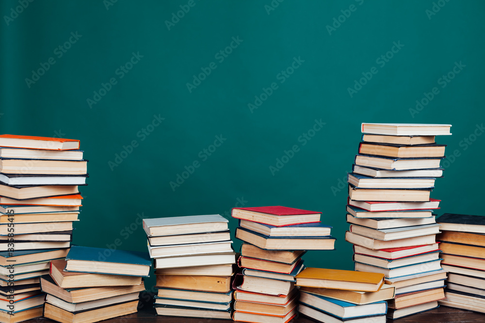many stacks of educational books for learning preparation for college exams on a green background many stacks of educational books for learning preparation for college exams on a green background