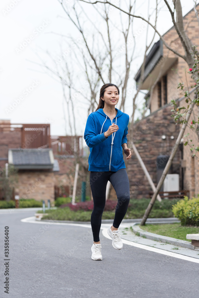 A young Asian woman jogging in the community