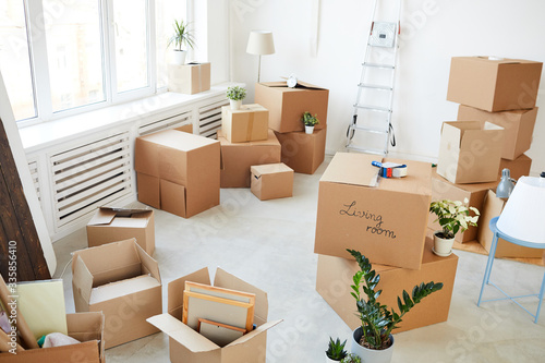 Wide angle background image of stacked cardboard boxes in empty room, moving, relocation and house decor concept, copy space photo