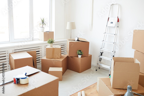 Fotografie Wide angle background of stacked cardboard boxes in empty white room, moving, re