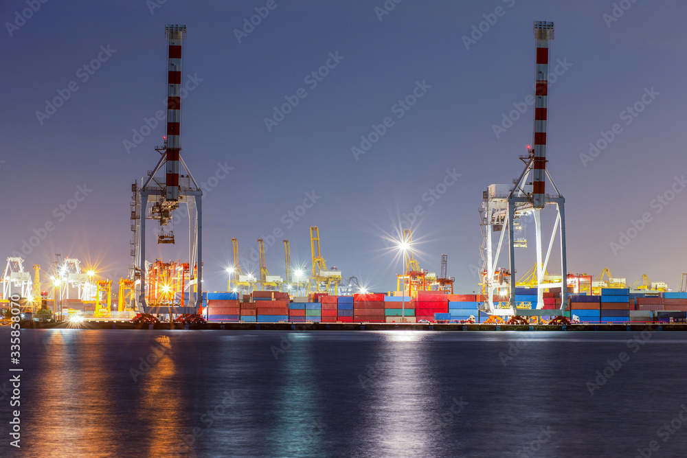 Industrial container with bridge crane working in shipyards at dusk to transport goods