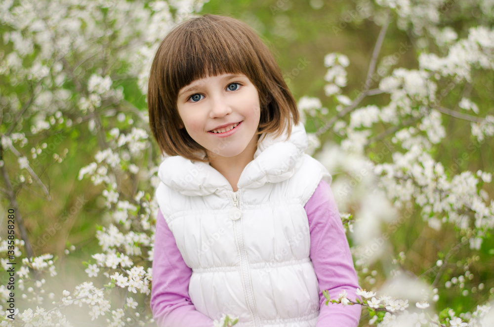 Portrait of a little smiling girl in spring garden Portrait of a little smiling girl in spring garden