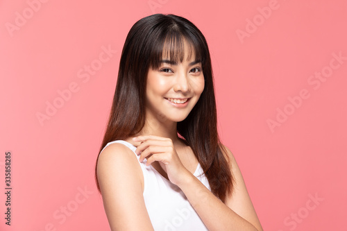 Young Beautiful Asian woman smile touching shoulder with clean and fresh skin Happiness and cheerful with positive emotional,isolated on pink background,Beauty Cosmetics and spa Treatment Concept © 220 Selfmade studio