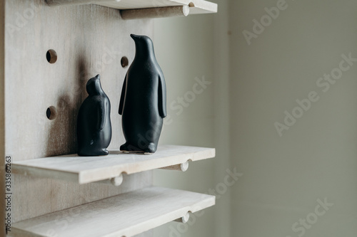 A couple black penguin figurine on wooden background. ceramic home decoration.