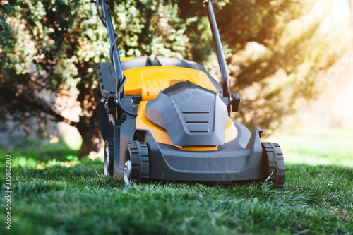 Electric lawn mower on a lawn at the garden