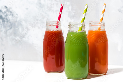 variety of fresh juices in bottles on white background