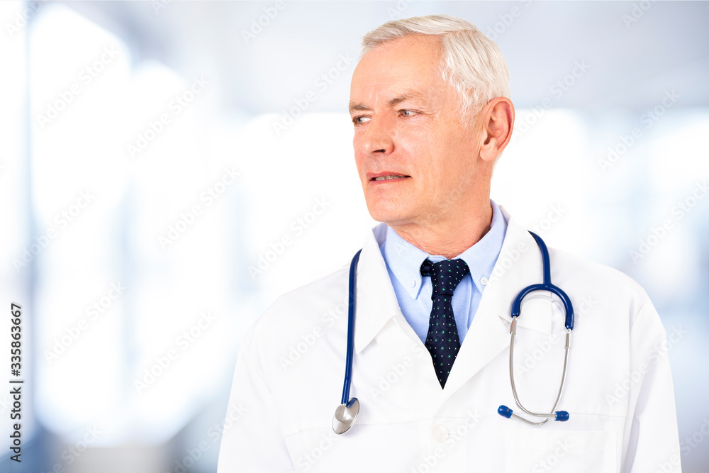 Senior male doctor portrait while standing in the hospital Senior male doctor portrait while standing in the hospital