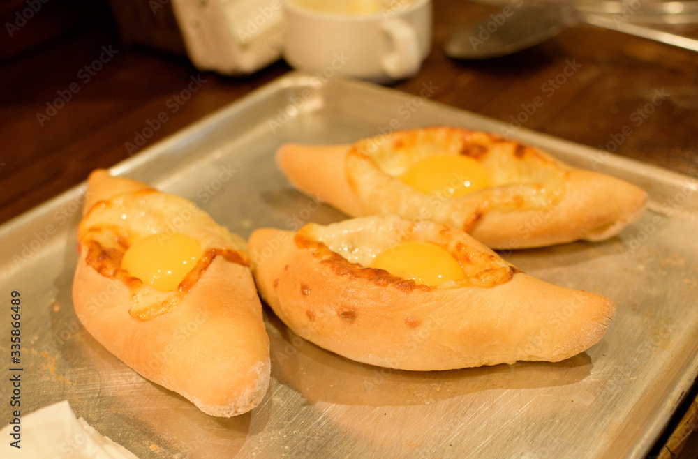 Ready khachapuri on a baking sheet. Top view Ready khachapuri on a baking sheet. Top view