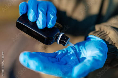 Antiseptic in a bottle on medical gloves © dimik_777