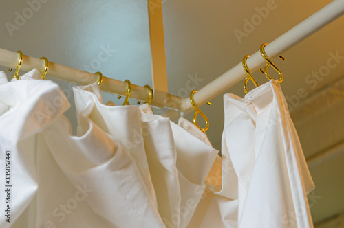 Brass hooks and cotton curtain on a rail of a Victorian Hospital ward. photo