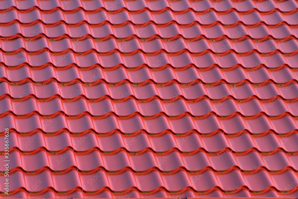 Roof of a house with modern red metal roof tiles Roof of a house with modern red metal roof tiles