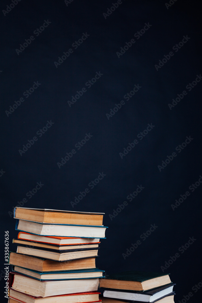 many stacks of educational books for learning preparation for college exams on a black background many stacks of educational books for learning preparation for college exams on a black background