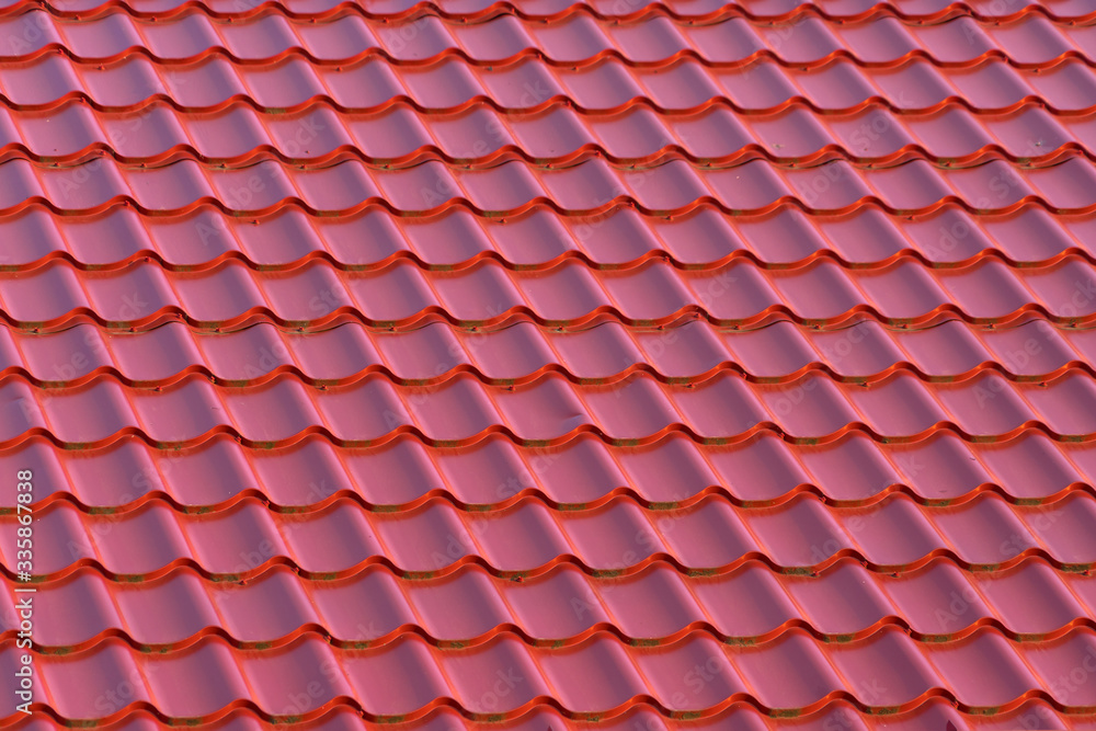 Roof of a house with modern red metal roof tiles Roof of a house with modern red metal roof tiles