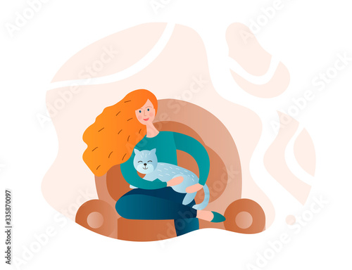 Girl with a cat in her arms on a home armchair