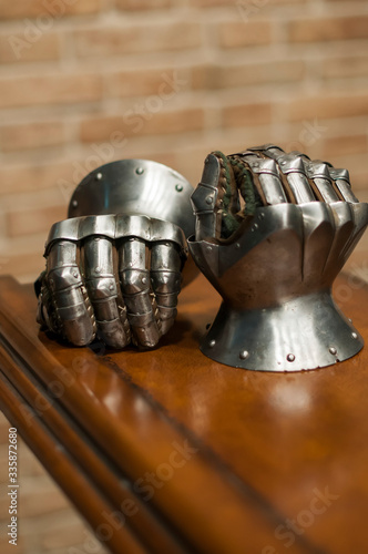 Medieval armor, detail of an ancient armor. Steel gloves on wooden background.