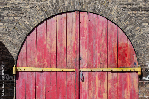 Portone in legno con assi verniciate di rosso