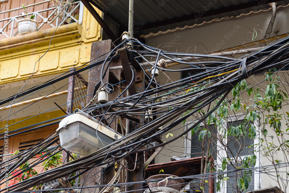 Hundreds of electrical cables are strewn over an electricity pole in a dangerous way in Hanoi, Vietnam.  This is the standard of power distribution all over Indochina.