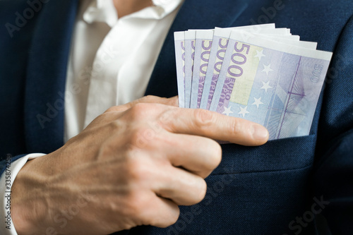 Money success concept. 500 euro bills in businessman jacket pocket. Symbol of success and wealth. photo