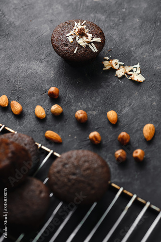 Chocolate cupcakes, muffins with banana and nuts, on a black table and a dark background. Top view, side view. Close-up and medium plan. Space for text.