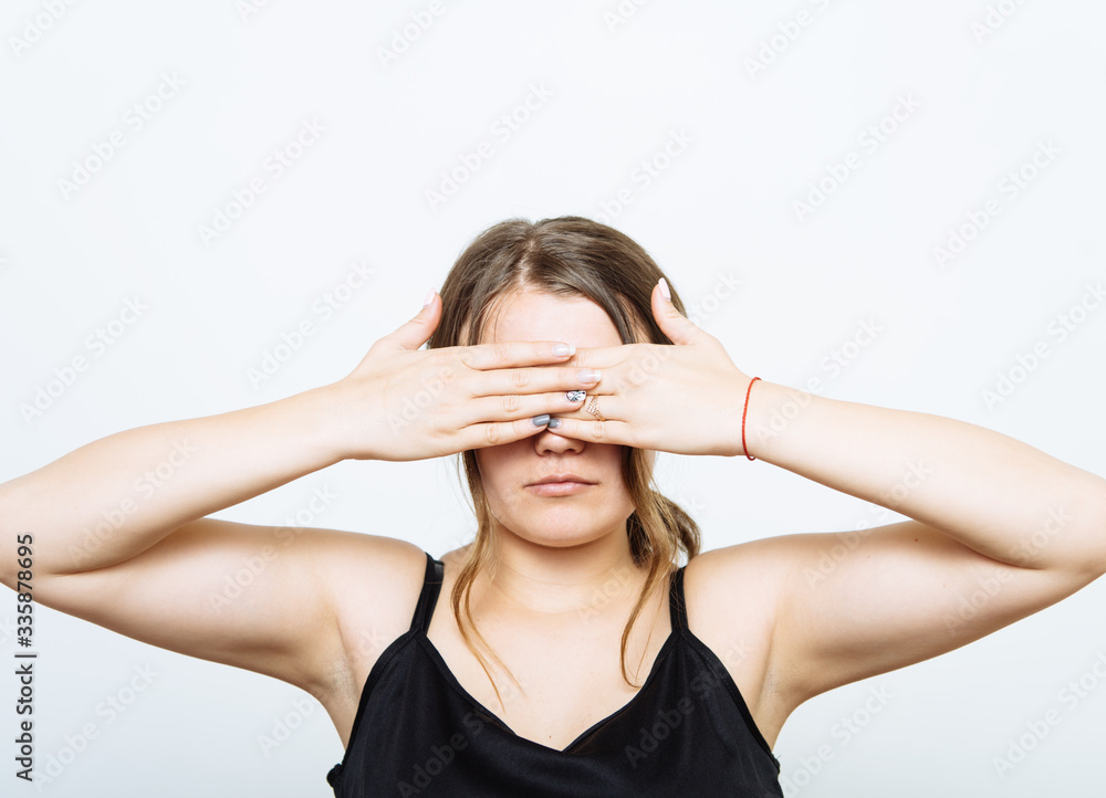 woman closes eyes with her hands