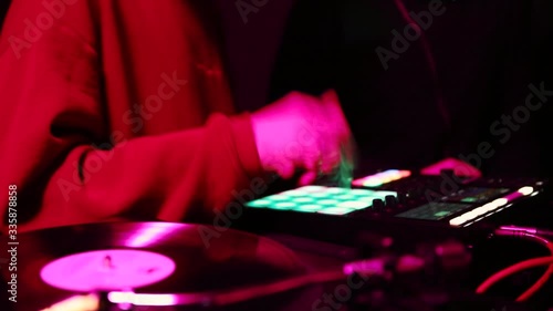 Hip hop producer plays beats on drum machine in night club.Electronic music composer playing new beat with digitial midi controller on concert stage in nightclub.Professional audio equipment on party photo