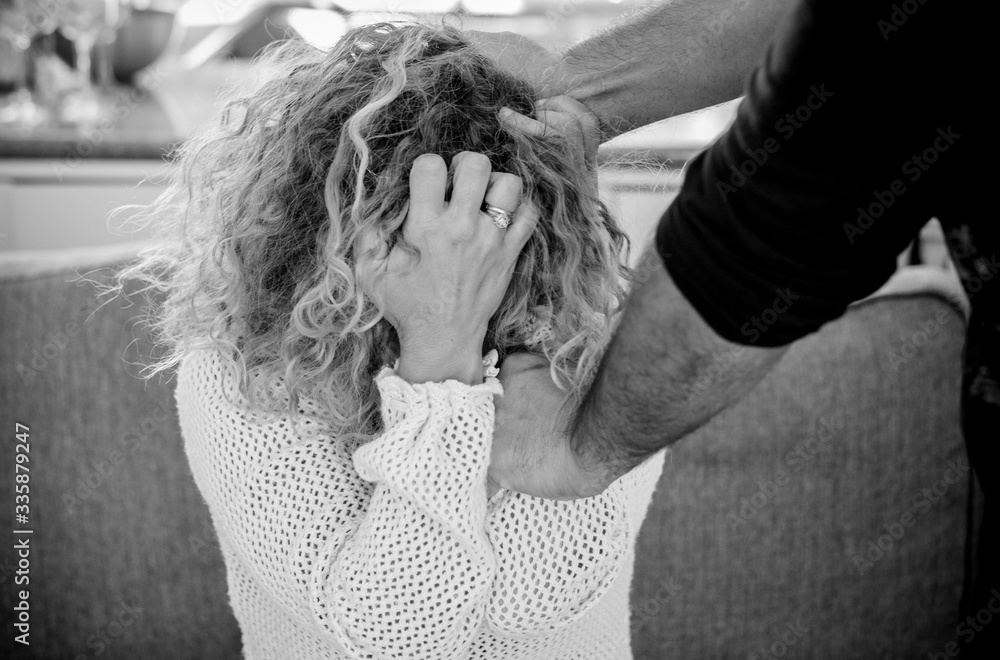 Violence on women concept with black and white image of caucasian lady protecting herself against bad husband unrecognizable man that try to beat her Violence on women concept with black and white image of caucasian lady protecting herself against bad husband unrecognizable man that try to beat her