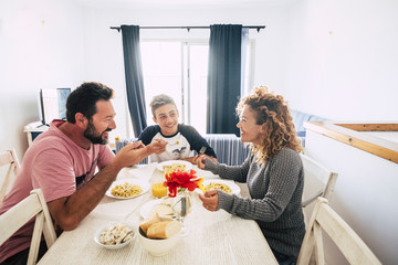 Concept of stay home lockdown quarantine people - caucasian family at home do lunch together enjoying the time - white house and italian food - people with different ages and generations