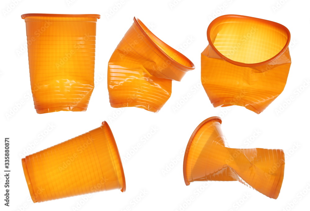Set wrinkly orange plastic cups isolated on white background, clipping path Set wrinkly orange plastic cups isolated on white background, clipping path
