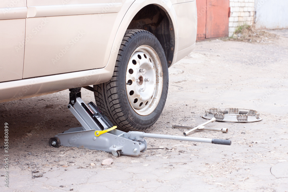 Fototapeta premium replacement of wheels on the car.Lifting the car with a Jack