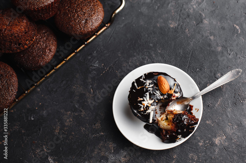 Chocolate cupcakes, muffins with banana, nuts and a Cup of coffee. On a black table and a dark background. Top view, side view. Close-up and medium plan. Space for text.