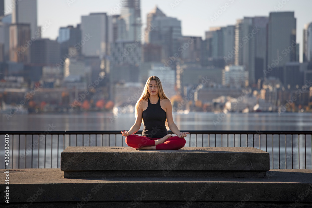 One Young Adult Woman in Zen Lotus Yoga  Pose Relaxing Stress Relief Meditation Alone in the City