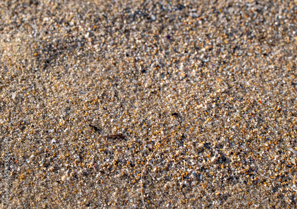 close up of sand on a beach with sun close up of sand on a beach with sun