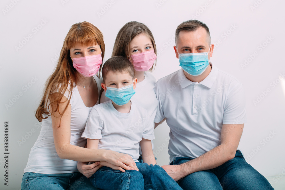young family in medical masks during home quarantine.
