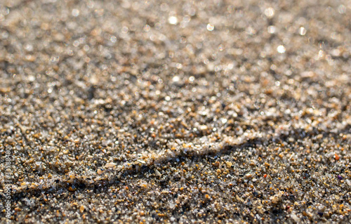 close up of sand on a beach with sun