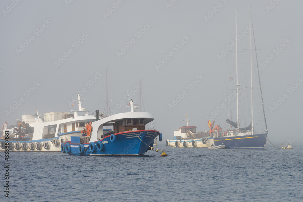 fishing boats anchored in foggy weather
