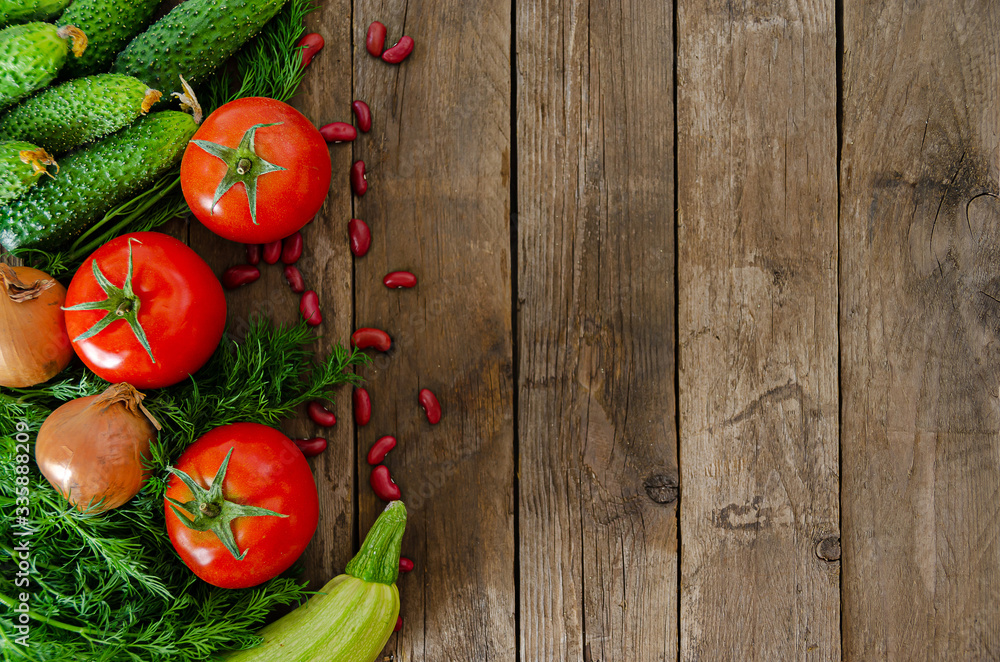 Fresh rustic vegetables on an old wooden table - tomatoes, cucumbers, onions, dill, beans. Fresh rustic vegetables on an old wooden table - tomatoes, cucumbers, onions, dill, beans.