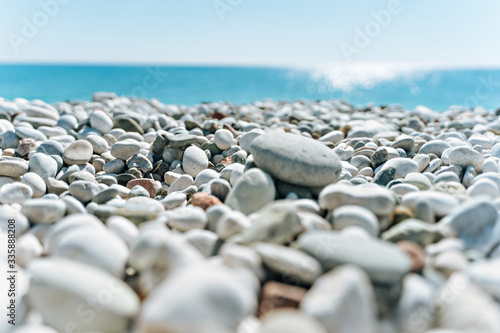 stones on the beach with a blue sea and blue sky on background 