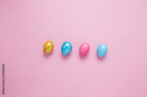 Multi-colored Easter eggs on a pink isolated background. Easter is a bright holiday.