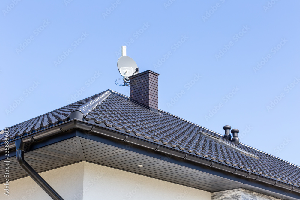 Corner of the new modern house with gutter, ventilation chimneys and