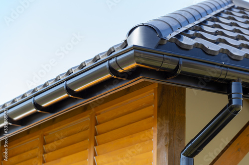 Corner of the new modern house with roof and gutter and wooden shutter photo