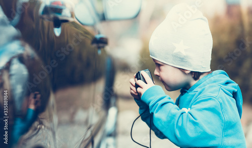 Boy with the camera as a car appraiser - Concept of car inspection in insurance - Motoring enthusiast - Shallow depth of field photo